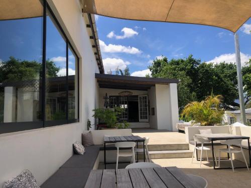 a patio with tables and chairs in front of a building at Tempel Wines in Paarl