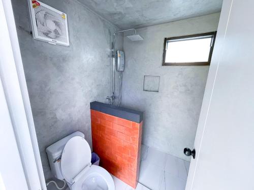ein kleines Bad mit einem WC und einem Fenster in der Unterkunft ธาราไลฟ์ in Ratchaburi