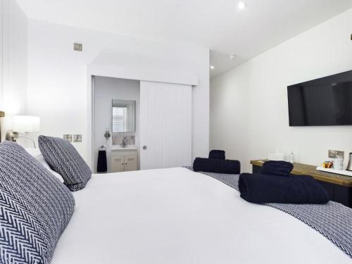 a bedroom with a large white bed with two blue chairs at Driftwood Boutique Guest House in Rhosneigr