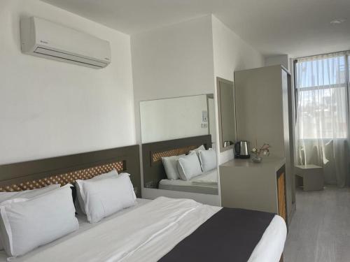 a bedroom with a large bed and a mirror at Alya Rooms in North Nicosia