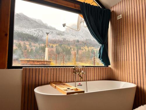 a bath tub in a bathroom with a window at View Piatra Craiului in Zărneşti