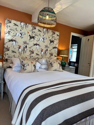 a bedroom with a large bed with a patterned wall at The Broadway Hotel in Broadway