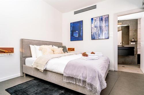 1 dormitorio con 1 cama grande con sábanas blancas en New Duplex 3 Bedroom with Jacuzzi, en Tel Aviv