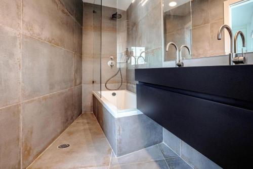 y baño con bañera, lavamanos y ducha. en New Duplex 3 Bedroom with Jacuzzi, en Tel Aviv