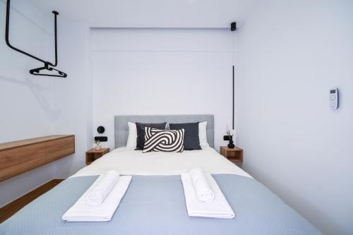 een slaapkamer met een groot bed en 2 witte handdoeken bij Luxury Downtown Apartment C2 in Thessaloniki