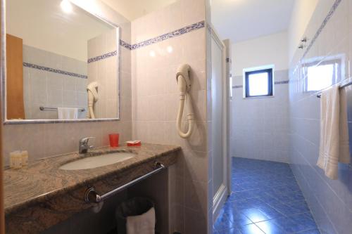 a bathroom with a sink and a shower at Villaggio Torre Ruffa Robinson in Capo Vaticano