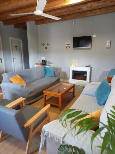 ein Wohnzimmer mit einem Sofa und einem Tisch in der Unterkunft CASA RURAL LA HOJA EL VALLE in Valdecaballeros