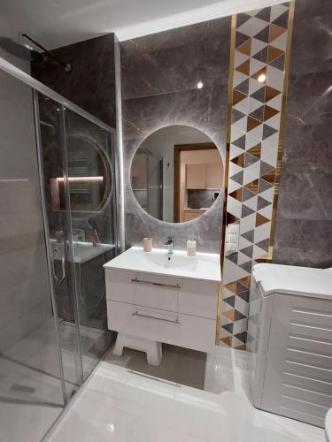 a bathroom with a sink and a mirror at Apartament Trójkąty i Kwadraty Karpatia Resort in Karpacz