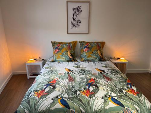 - une chambre avec un lit orné d'oiseaux colorés dans l'établissement Les Appartements du Cep’t, à Mazamet