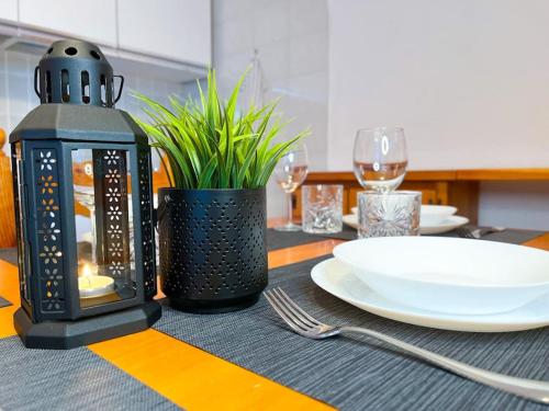 a black lantern sitting on a table with a plate at 150m DALLE PISTE - Parcheggio Gratis in Sella della Turra