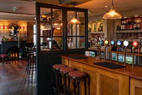 a bar in a restaurant with stools at The Rising Sun in Backwell