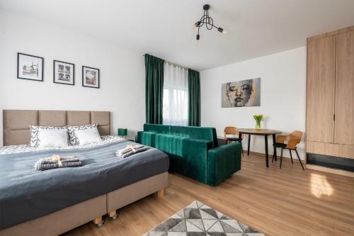 a bedroom with a bed and a chair and a table at Apartamenty RIO Skarbimierz-Osiedle in Skarbimierz Osiedle