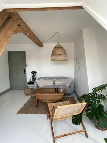 uma sala de estar com um sofá e uma mesa em Appartement cosy et lumineux au cœur de Montreuil em Montreuil-sur-Mer