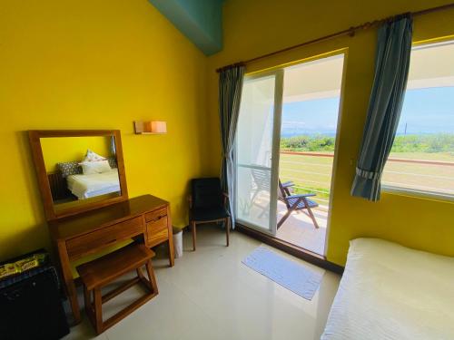 a bedroom with a bed and a mirror and a window at Kenting COMIC B&B in Hengchun