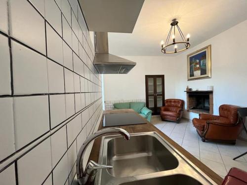 a kitchen with a sink and a living room at Casa Al Vino sul Vesuvio in Pollena Trocchia