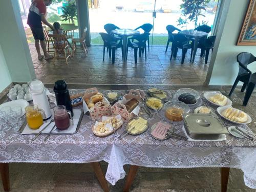 uma mesa com uma toalha de mesa com comida em Pousada Believe na Praia Grande