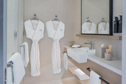 a white bathroom with a sink and a mirror at Vida Dubai Marina & Yacht Club in Dubai