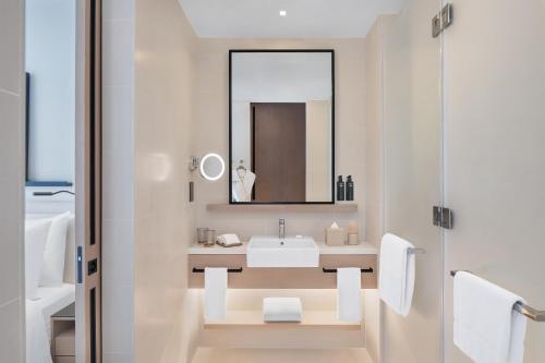 a white bathroom with a sink and a mirror at Vida Dubai Marina & Yacht Club in Dubai