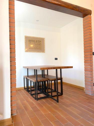 a table and benches in a room with a wall at Chalet Bornhome relax, sport e cultura altopiano del sole 6 ospiti - pet Frendly in Borno