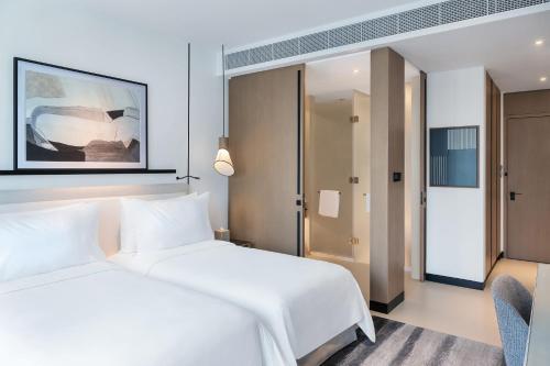 a hotel room with two beds and a chair at Vida Dubai Marina & Yacht Club in Dubai