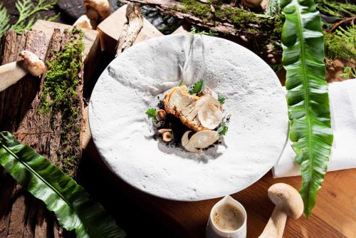 a plate of food with mushrooms on a table at La Ferme Saint Simeon Spa - Relais & Chateaux in Honfleur