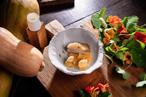 a bowl of food on a wooden table with vegetables at La Ferme Saint Simeon Spa - Relais & Chateaux in Honfleur