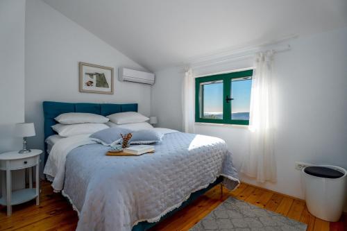 ŽrnovnicaにあるVilla Runjeのベッドルーム1室(青いヘッドボード付きのベッド1台、窓付)