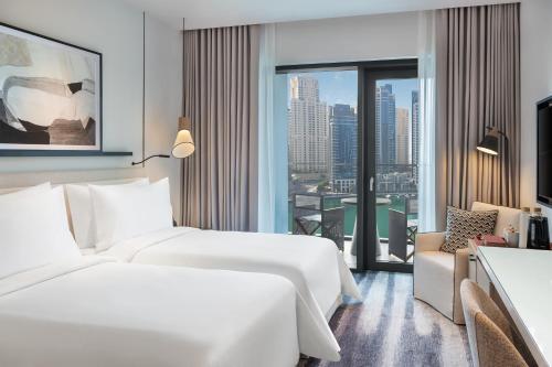 two beds in a hotel room with a view at Vida Dubai Marina & Yacht Club in Dubai