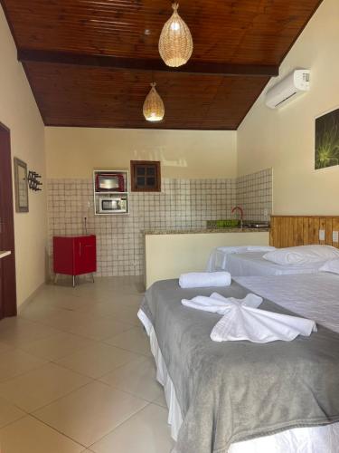 a bedroom with two beds with towels on them at Pousada Lua Nova Charmosa Pipa in Pipa