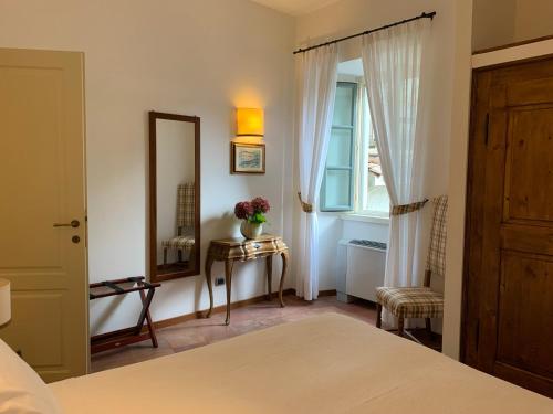 a bedroom with a bed and a mirror and a window at Il Poggio Di Bellagio in Bellagio