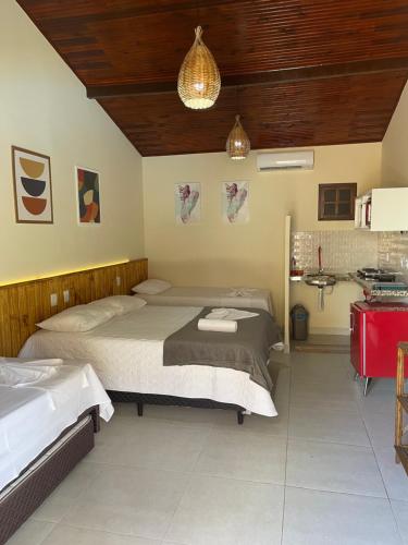 1 dormitorio con 2 camas y lavamanos. en Pousada Lua Nova Charmosa Pipa, en Pipa