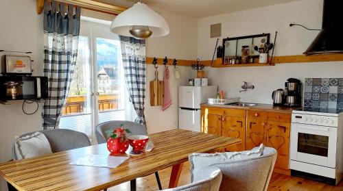 una cucina con tavolo in legno, sedie e tavolo di Haus Moni a Bad Goisern