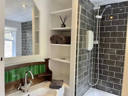 a bathroom with a sink and a shower at Peace Cottage in Whitstable