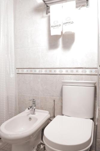a bathroom with a white toilet and a sink at Asmald Palace Hotel in Kokand