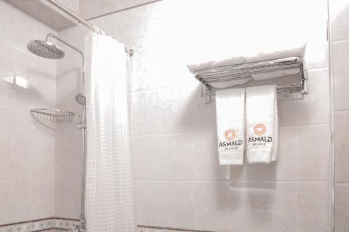 a bathroom with two towels hanging on a shower at Asmald Palace Hotel in Kokand