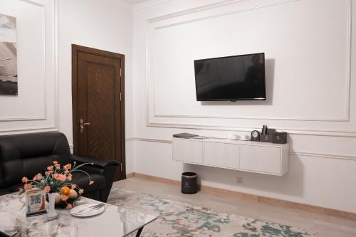 a living room with a television on a wall at Asmald Palace Hotel in Kokand