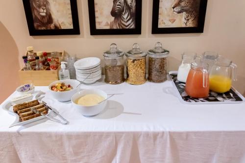 a table with a white table cloth with food on it at Sunbird Lodge in Phalaborwa
