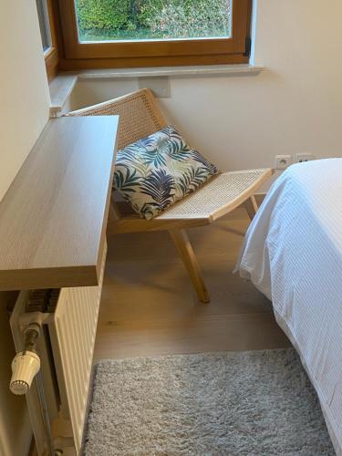 a bench with a pillow sitting next to a bed at La Clé des Champs in Tervuren