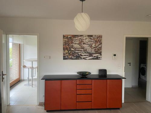 a kitchen with a counter and a painting on the wall at La Clé des Champs in Tervuren