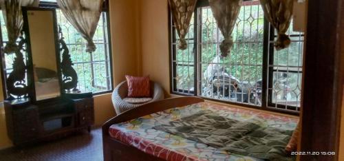 a bedroom with a bed in a room with windows at Beth Meon Homestay in Darjeeling