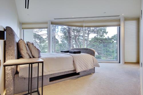 a bedroom with a bed and a large window at Luxury 3 bed flat with large terrace, sea views and hot tub in Canford Cliffs