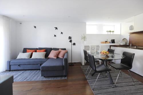 uma sala de estar com um sofá azul e uma mesa em Santa Joana Apartments with garden and heated pool em Lisboa