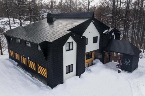 a black and white house in the snow at Onpoint Madarao in Myoko