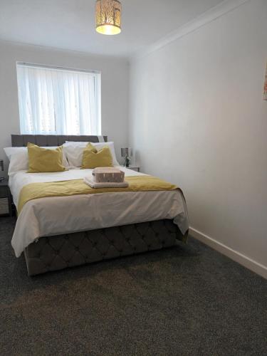 a bedroom with a large bed with yellow pillows at Luxurious 4 bed adorable house in Willington in Willington