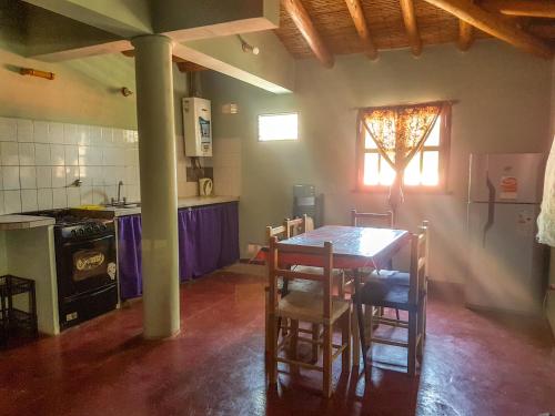 kuchnia ze stołem, krzesłami i kuchenką w obiekcie Lo del Gaucho w mieście Tilcara