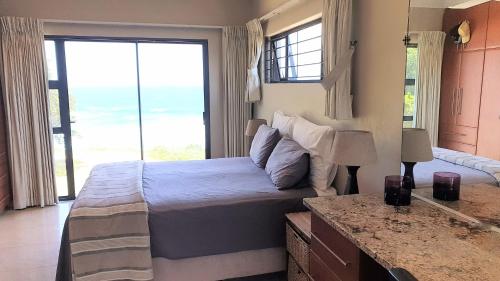 a bedroom with a bed and a large window at Sea Escape in Sea Park