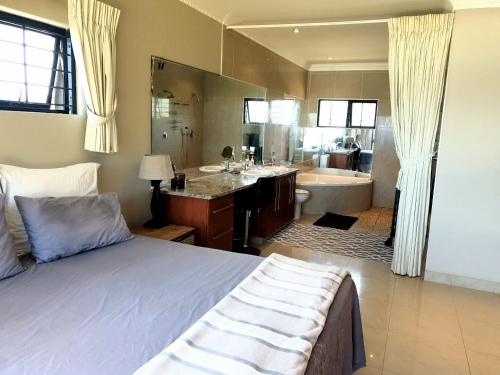 a bedroom with a bed and a bathroom with a tub at Sea Escape in Sea Park