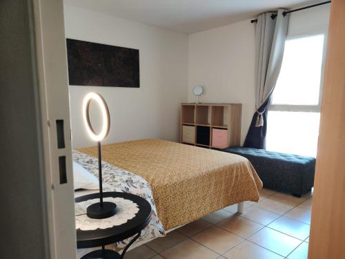 une chambre avec un lit et une lampe sur une table dans l'établissement Appartement spacieux 2 pièces , climatisé, Wifi, 2 à 4 couchages PORTIRAGNES PLAGE LXCS176, à Portiragnes