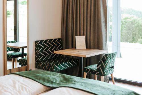 a room with a bed and a table and chairs at Kickmaier's in Kirchbach in Steiermark