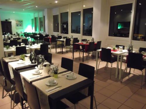 シュトゥットガルトにあるBusinesshotel & Appartements Stuttgart-Vaihingenのレストラン内のダイニングルーム(テーブル、椅子付)